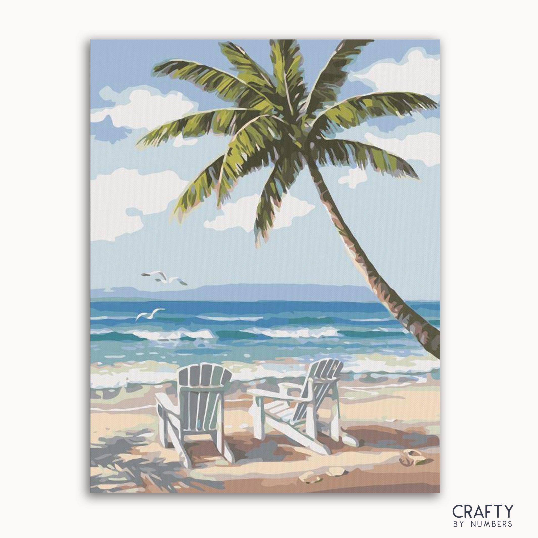 A paint-by-numbers kit image featuring a tropical beach scene with chairs under a palm tree, with the ocean and sky in the background.