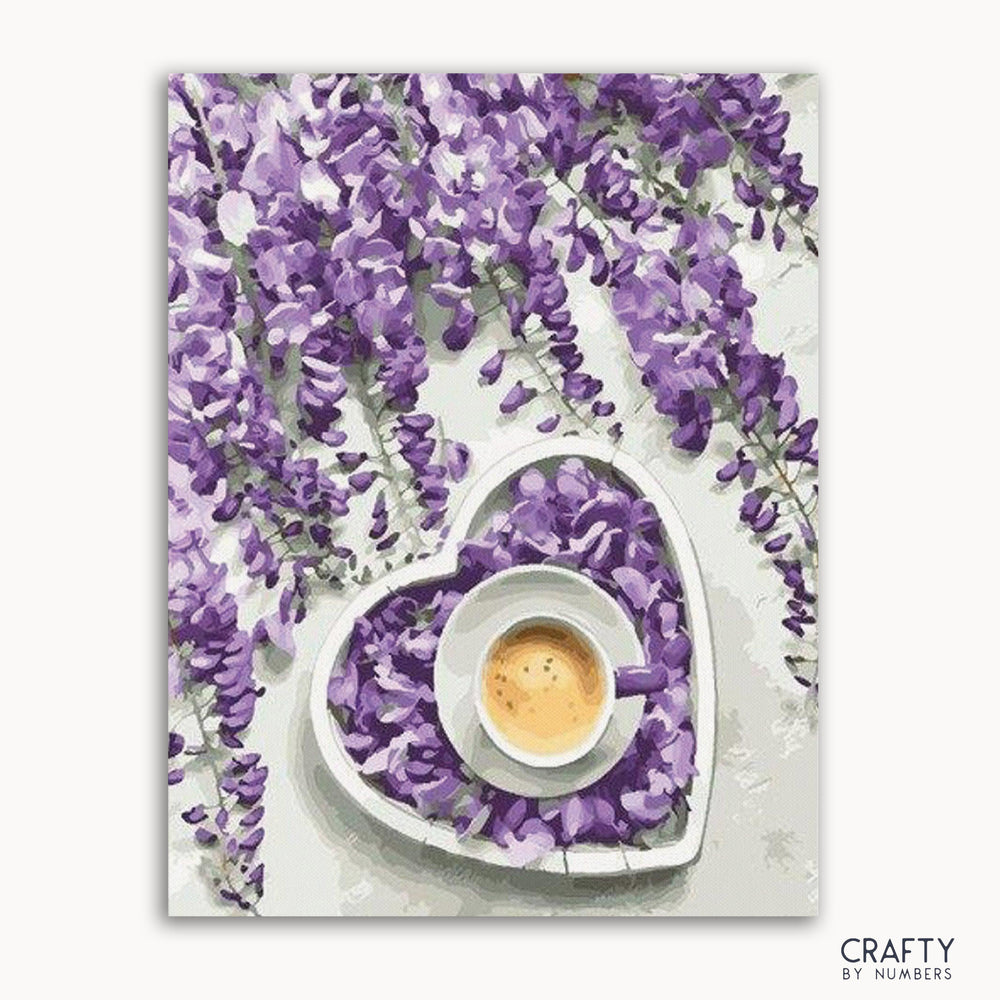 A paint-by-numbers kit depicting a cup of coffee with purple flowers around it, primarily in a heart-shaped arrangement on a white background.