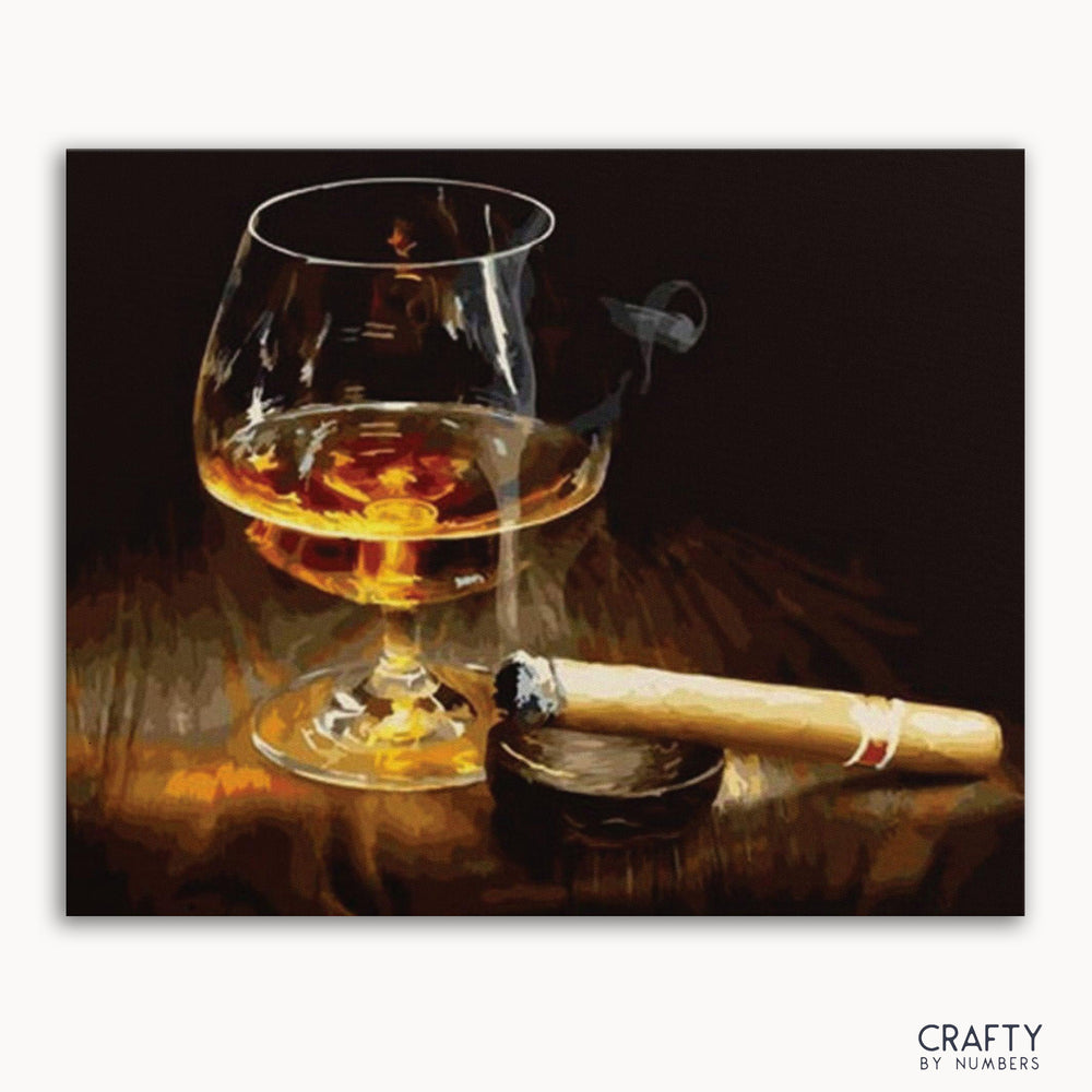 A paint by numbers kit depicting a glass of whiskey and a cigar on a wooden surface.