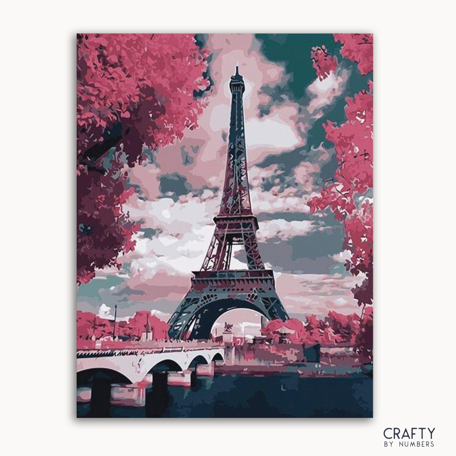 Una imagen de kit de pintura por números que muestra la Torre Eiffel con un cielo colorido y árboles de fondo.