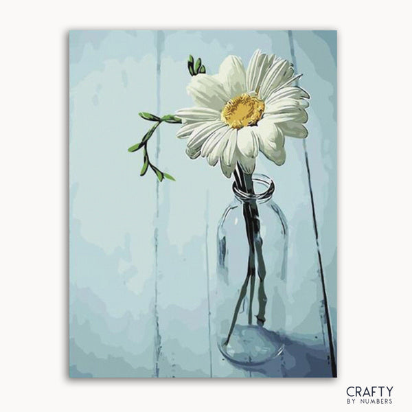 A paint-by-numbers kit image featuring a white flower in a clear bottle with a blue background.