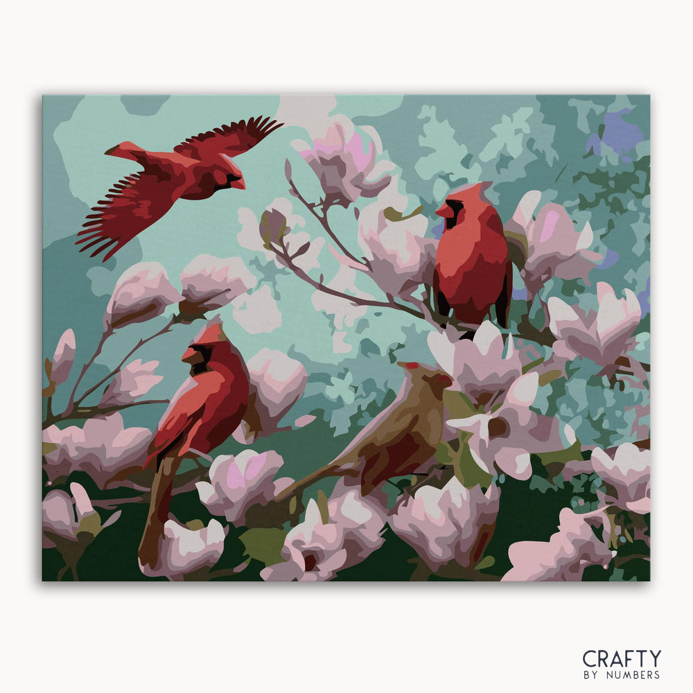 A paint-by-numbers kit image featuring a picture with red birds perched on branches with pink flowers.