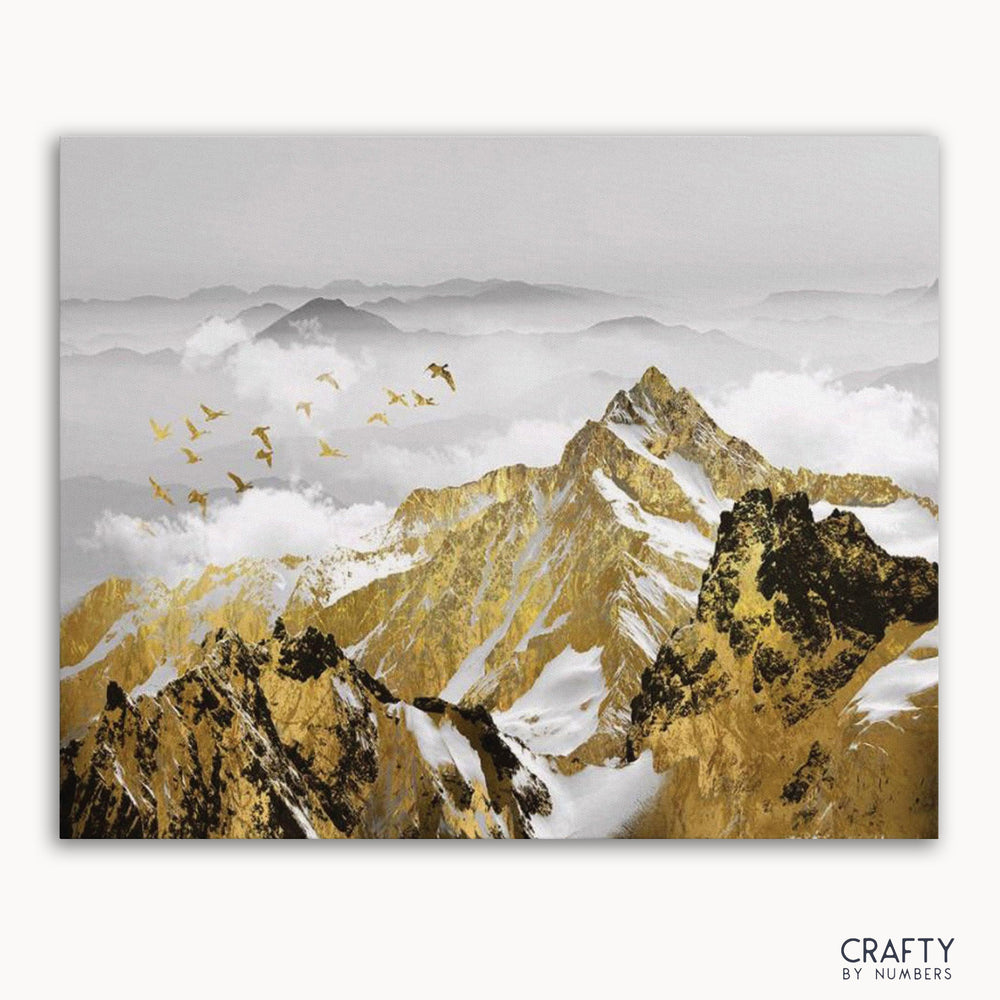 A paint by numbers kit depicting a golden mountains landscape with birds in flight, without a frame.