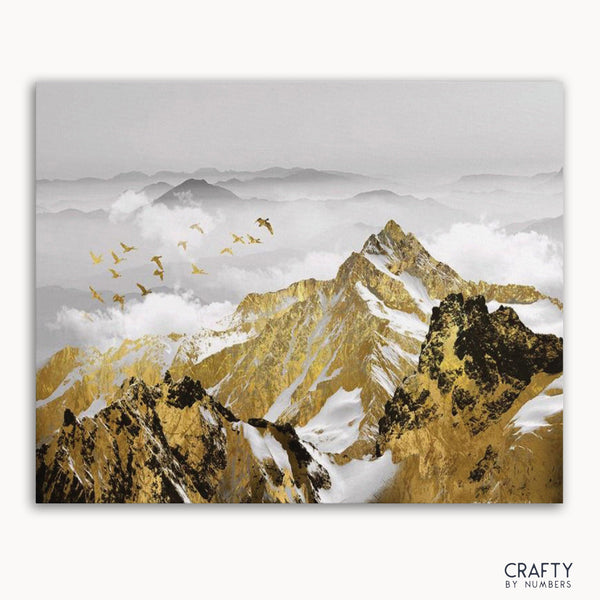 A paint by numbers kit depicting a golden mountains landscape with birds in flight, without a frame.