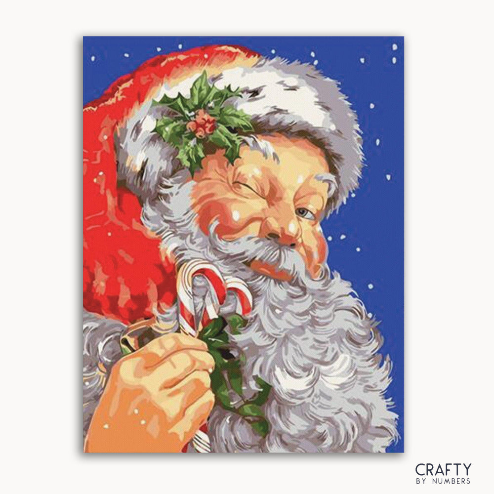 A paint-by-numbers kit depicting a mischievous Santa Claus with a red hat, white beard, and holding a candy cane, set against a blue background with snow.