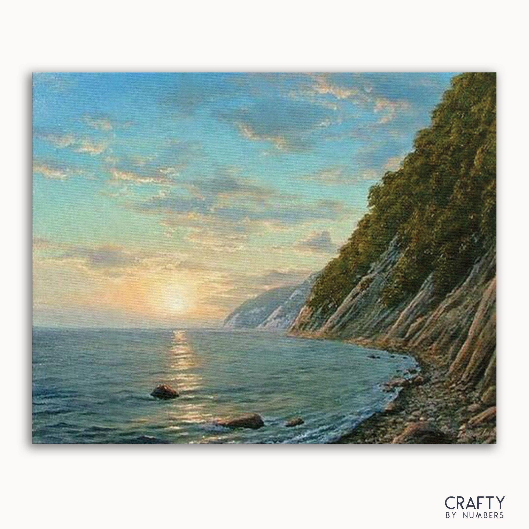 A paint-by-numbers kit depicting a mountain river sunset scene with a canvas placed against a model representing the Earth's curvature.