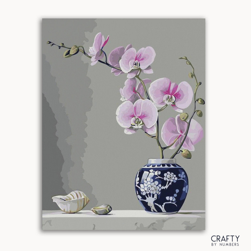 A paint-by-numbers kit image featuring a vase with orchid flowers on a grey background, included with Crafty by Numbers branding.
