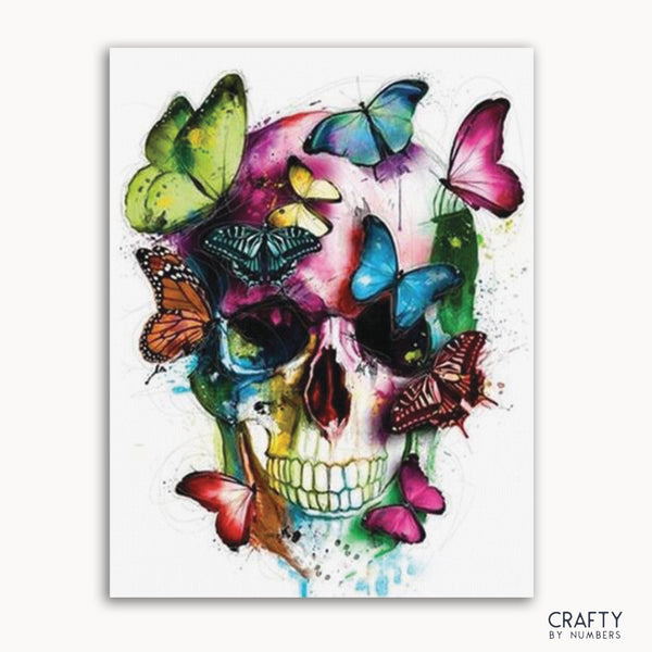 A colorful painting depicting a skull with butterflies around it, with a 'Crafty by Numbers' logo in the bottom right corner.