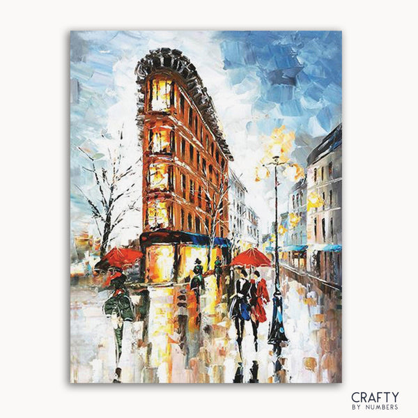 A paint-by-numbers kit image featuring a cityscape with rain, including buildings and people with umbrellas.