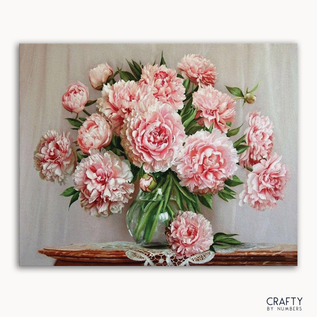 A paint-by-numbers kit image featuring a vase with pink flowers, labeled 'CRAFTY by Numbers'.