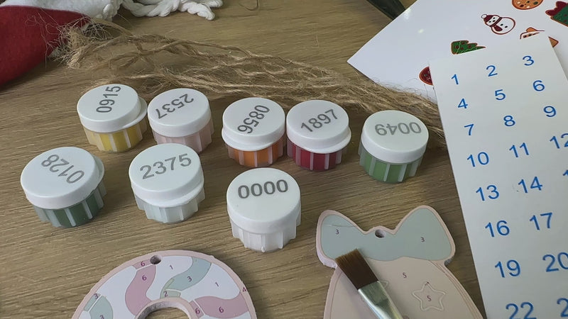 Assorted Christmas ornaments from North Pole Bakery displayed on a tree with twinkling lights.