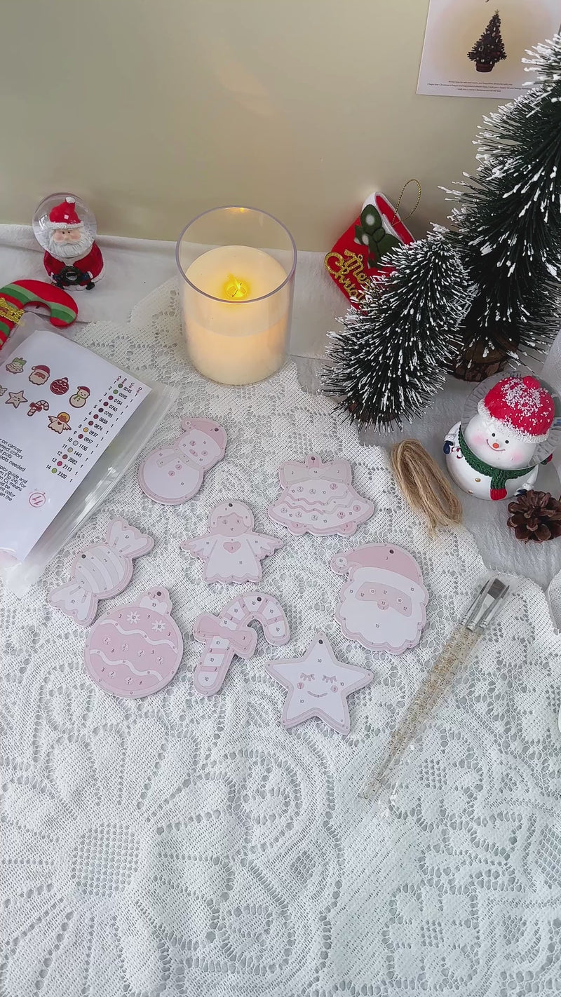 Close-up of glittery holiday ornaments with “Sweet Noel Joy” lettering surrounded by twinkling lights and pine branches.