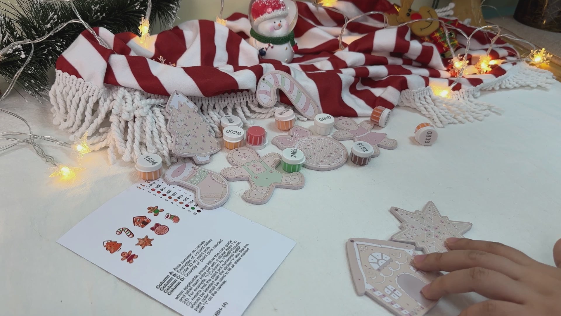Load video: Colorful gingerbread-themed Christmas ornaments hanging on a festive tree, featuring candy cane stripes and cheerful designs.