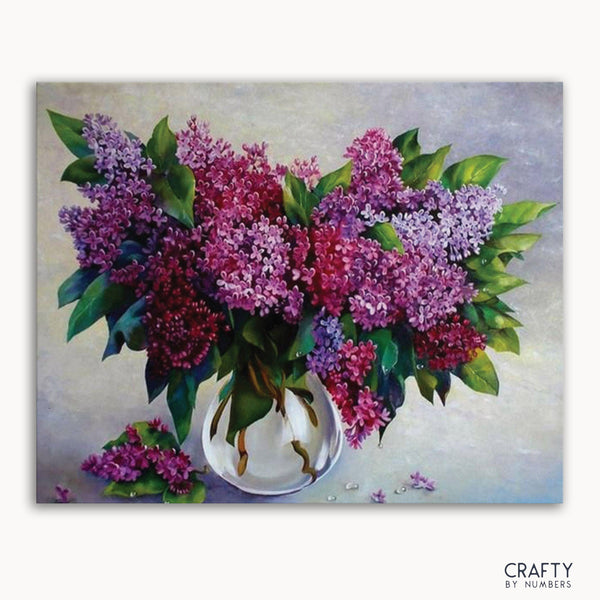 A paint-by-numbers kit image featuring a vase with purple flowers.