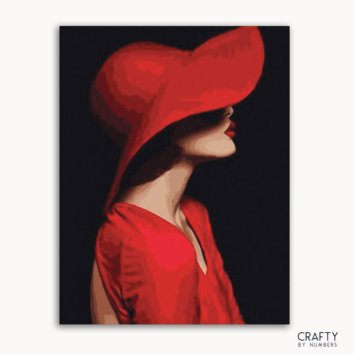 A paint-by-numbers kit depicting a lady wearing a red hat, with a predominantly red and black color scheme.