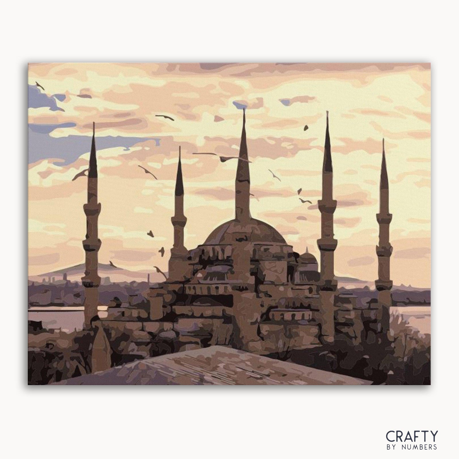 Ein Malen-nach-Zahlen-Setbild mit einer Moschee mit Minaretten vor einem Himmel mit Wolken und Vögeln.