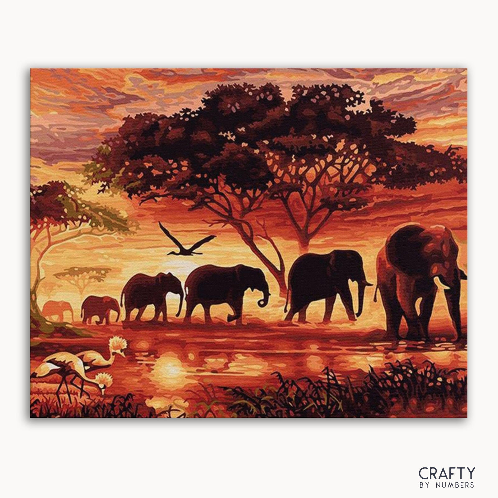 Un kit de pintura por números que representa una escena de puesta de sol con elefantes y árboles.