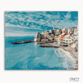 A paint-by-numbers kit depicting a cityscape by the ocean with blue skies and buildings lining the coast.