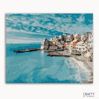 A paint-by-numbers kit depicting a cityscape by the ocean with blue skies and buildings lining the coast.
