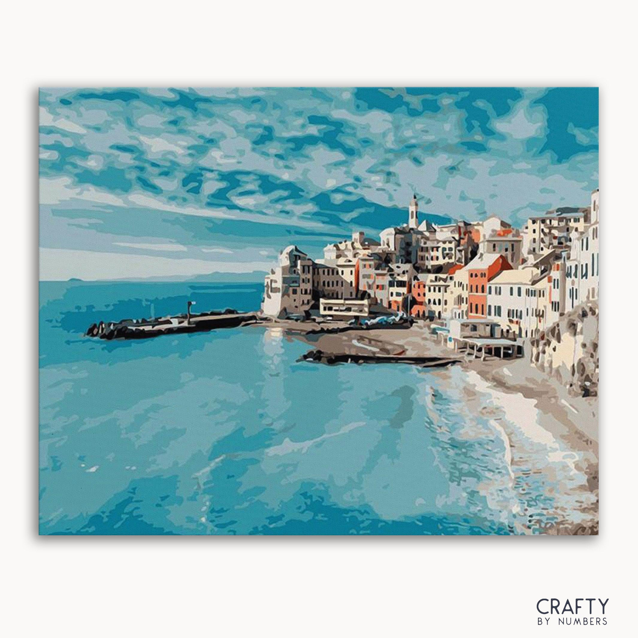 A paint-by-numbers kit depicting a cityscape by the ocean with blue skies and buildings lining the coast.