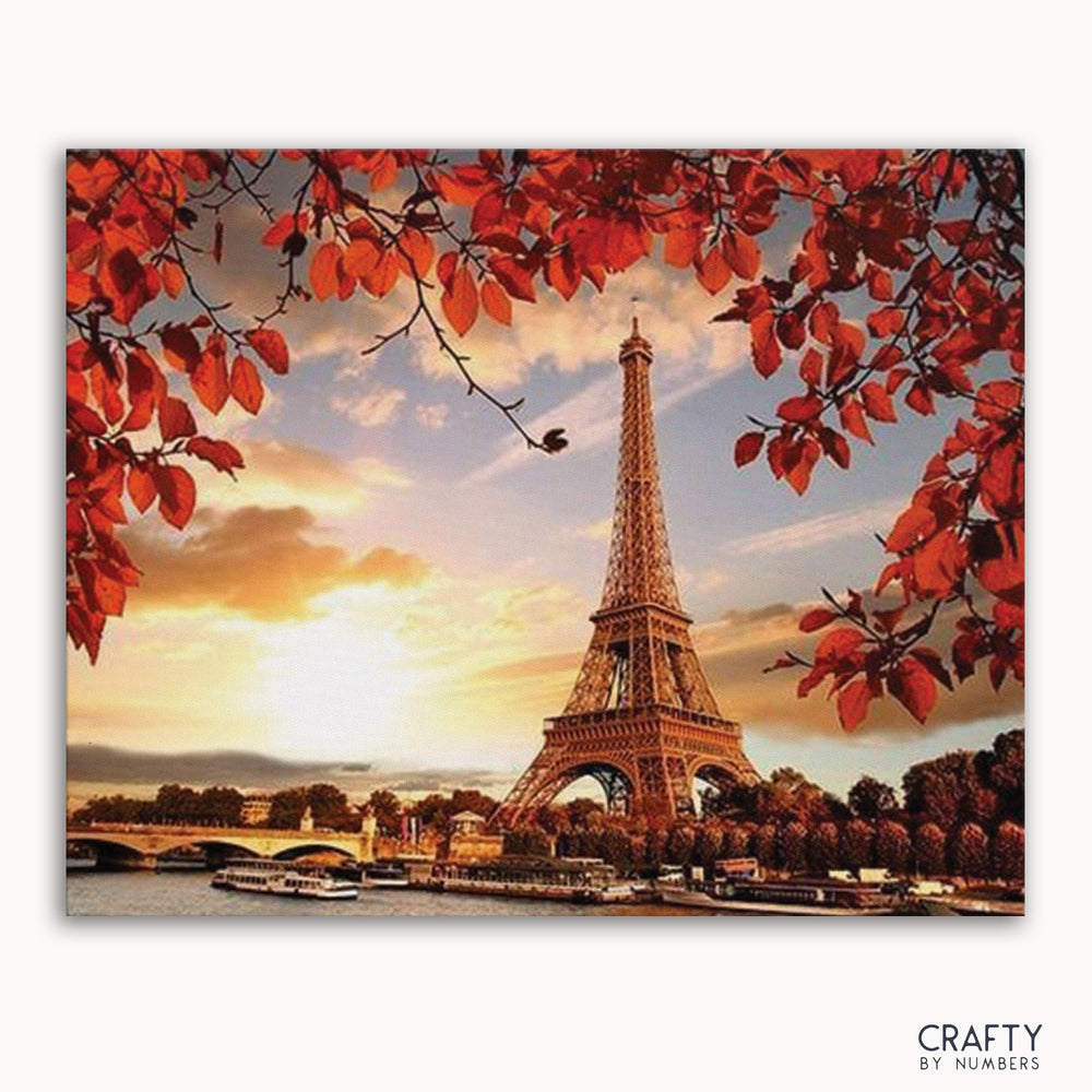A paint-by-numbers kit image featuring the Eiffel Tower with autumn leaves in the foreground.