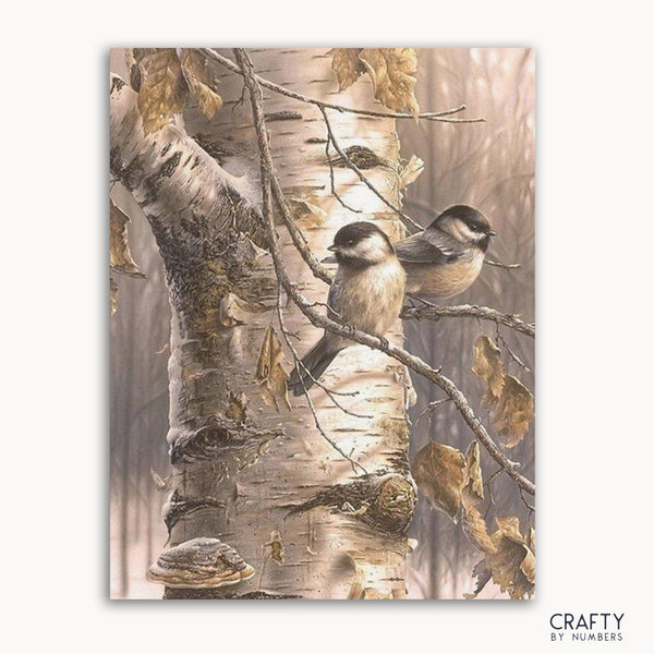 A paint by numbers kit depicting two birds on a birch tree.