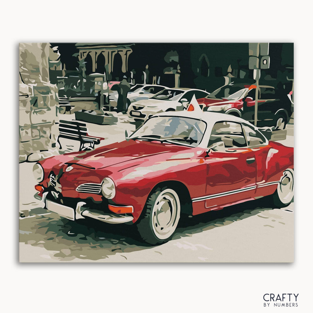 A paint by numbers kit featuring a vintage red car on a street background.