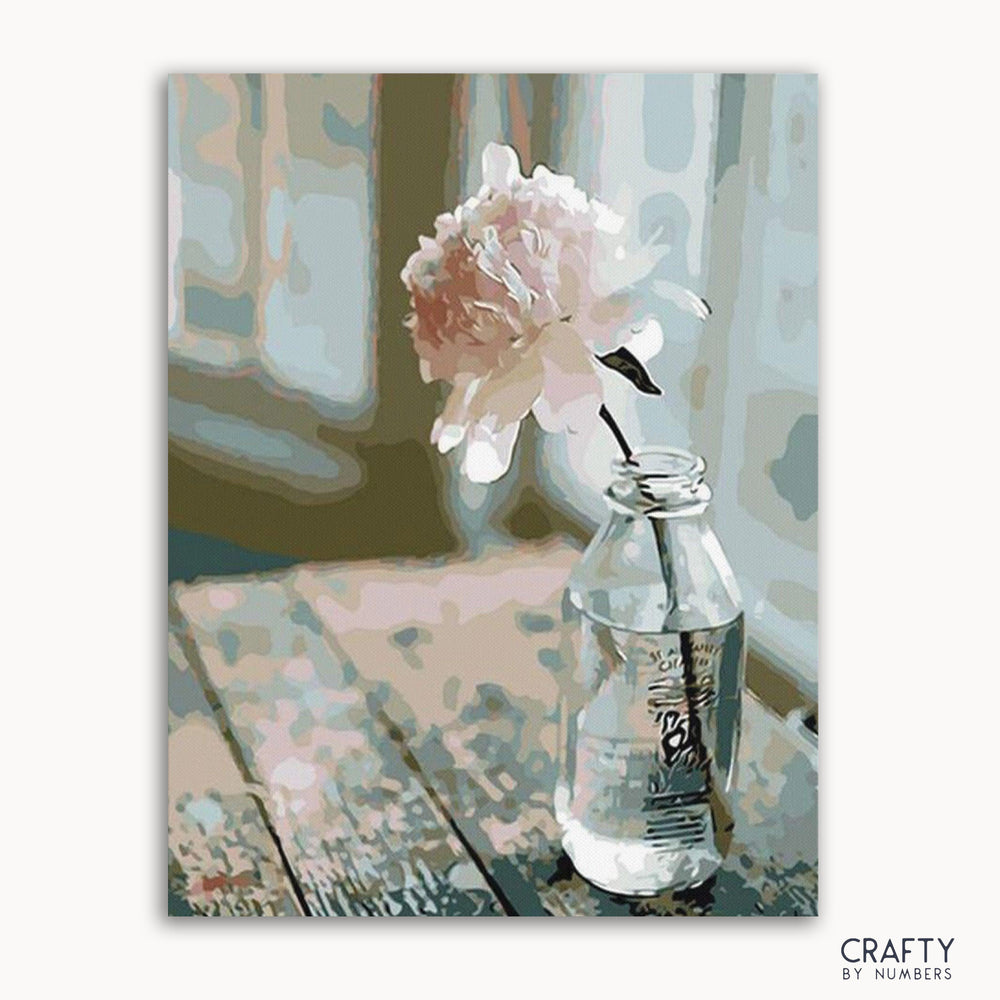 A paint-by-numbers kit image featuring a white flower in a clear vase on a wooden surface with a blurred background.