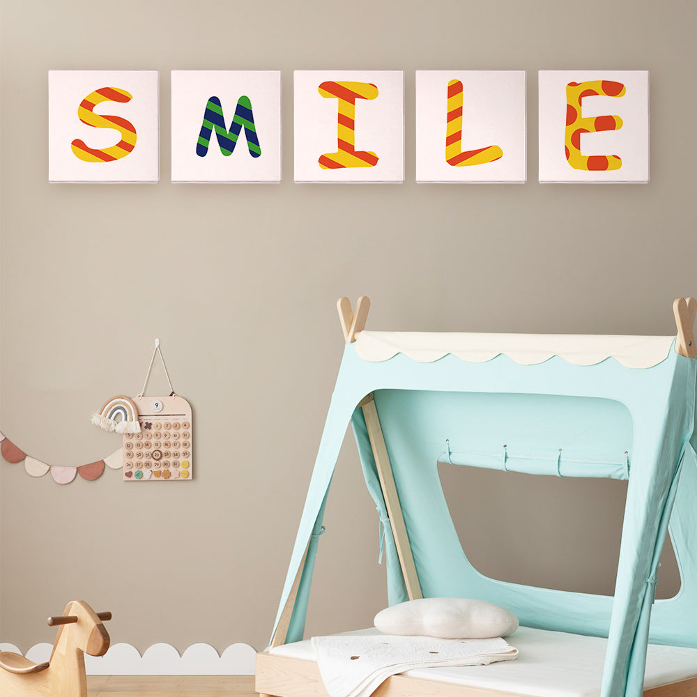 Plusieurs toiles Zigzag Zest Alphabet terminées disposées pour épeler sourire un mot coloré avec des motifs en zigzag dynamiques